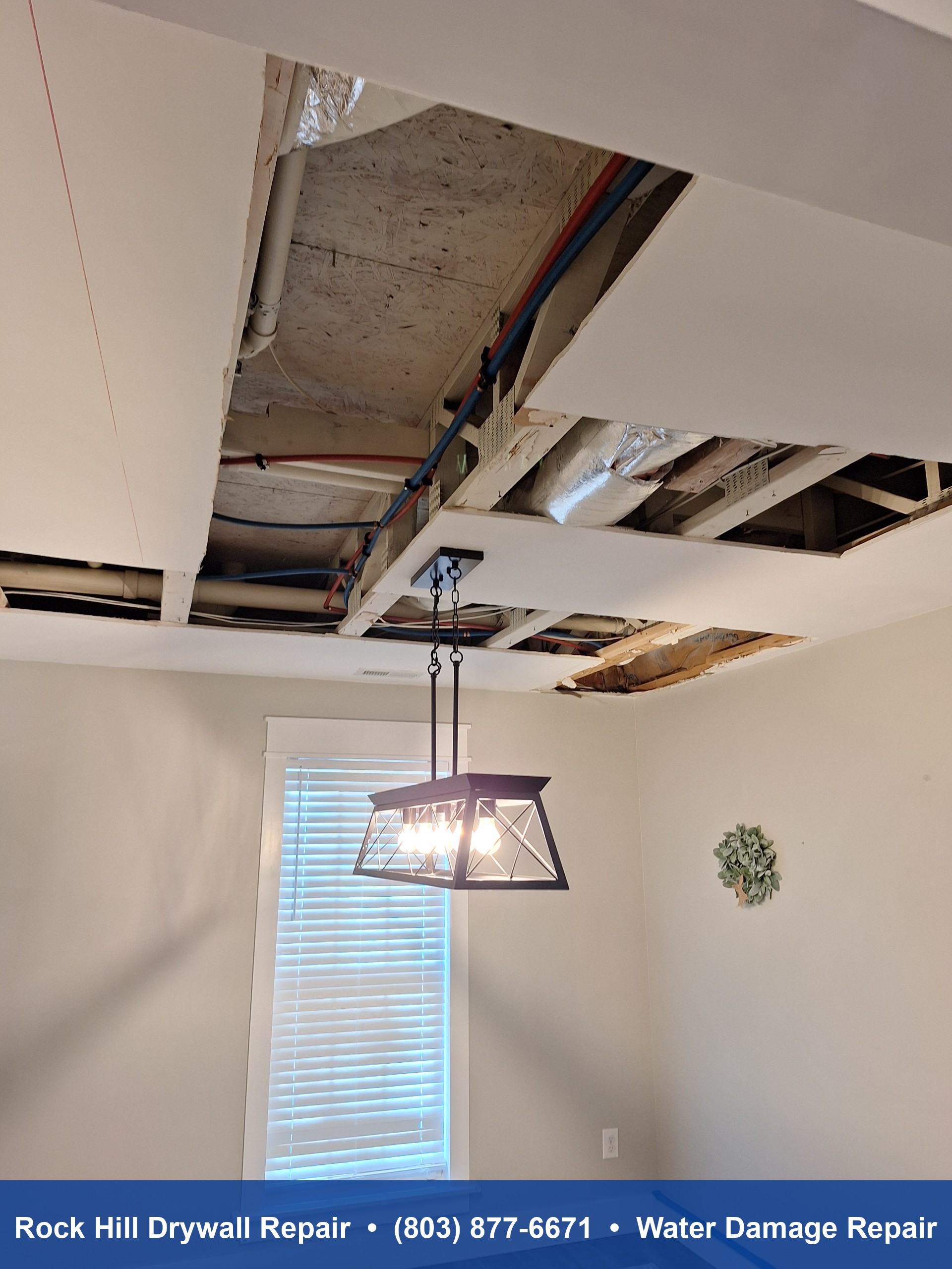 Dining room ceiling water damage repair showing exposed framing and pipes in Rock Hill SC